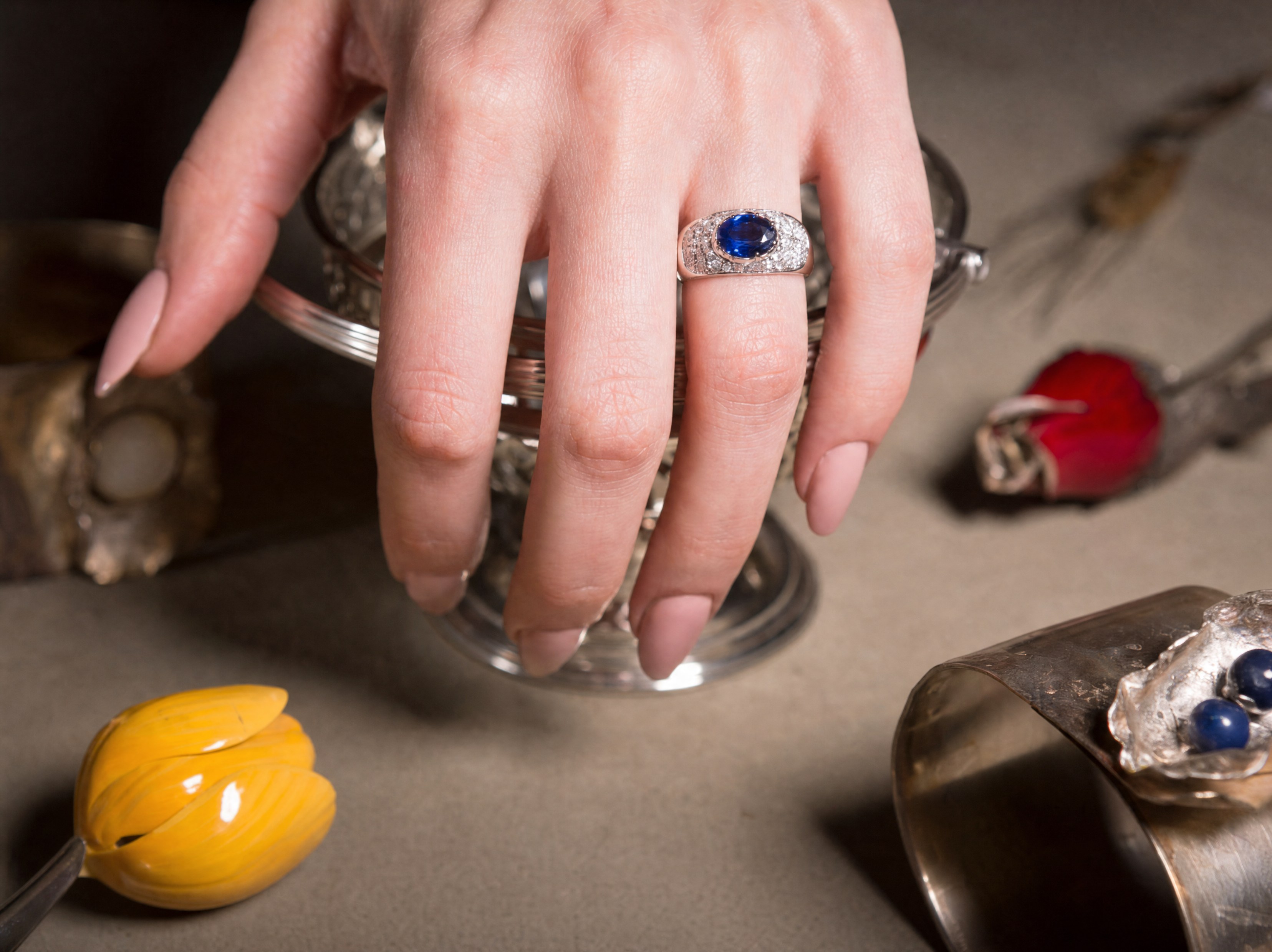 A finished ring set with a blue sapphire, worn on the hand