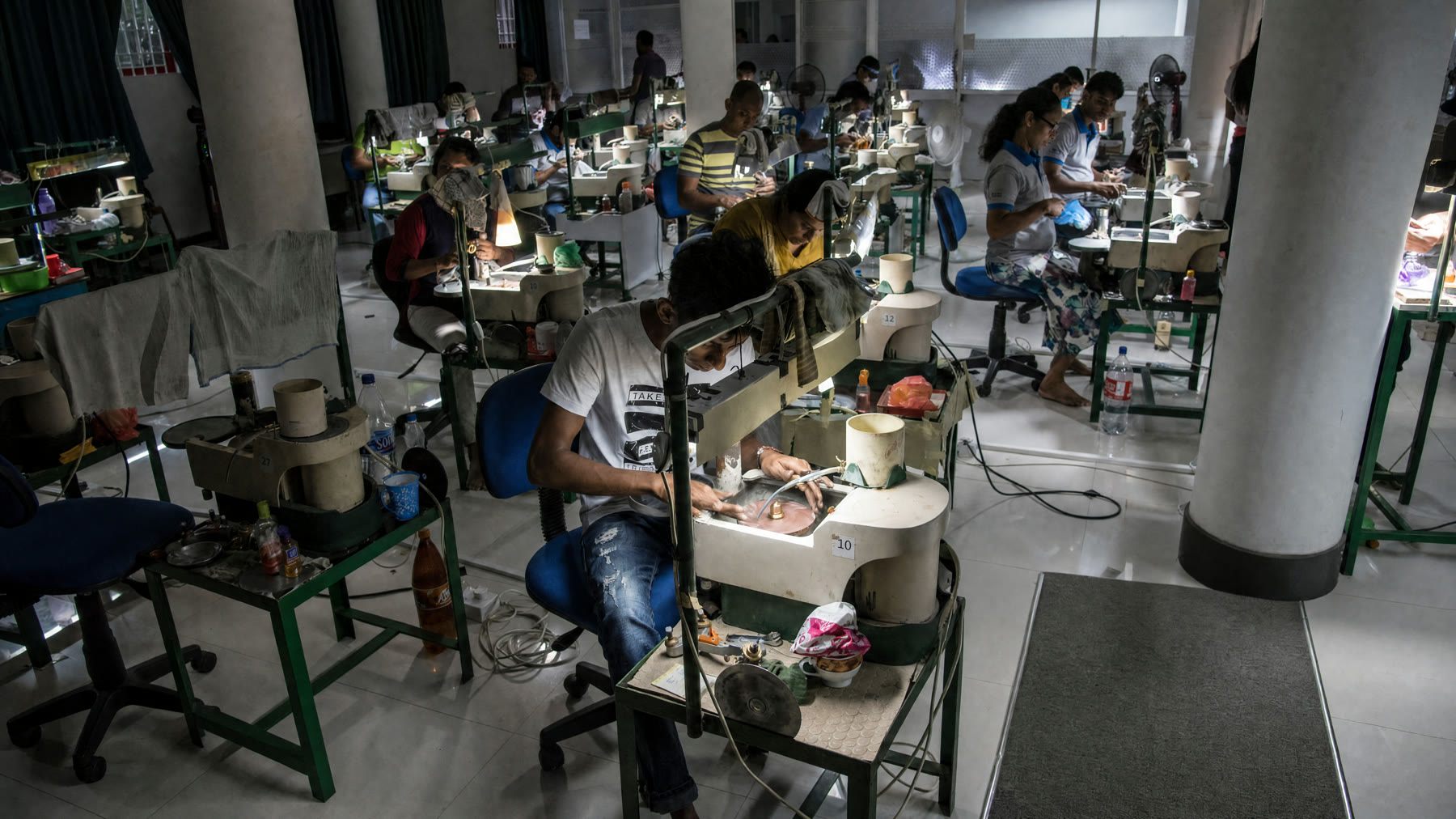 Cutters at their wheels on the floor of the Shwe Sin cutting studio
